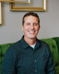 Mike Clouse, Career Coach, smiling for the camera while sitting on Haven Collective's green couch.