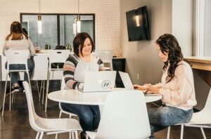 Coworkers sitting in the lounge at Haven Collective Upper Arlington working on laptops.